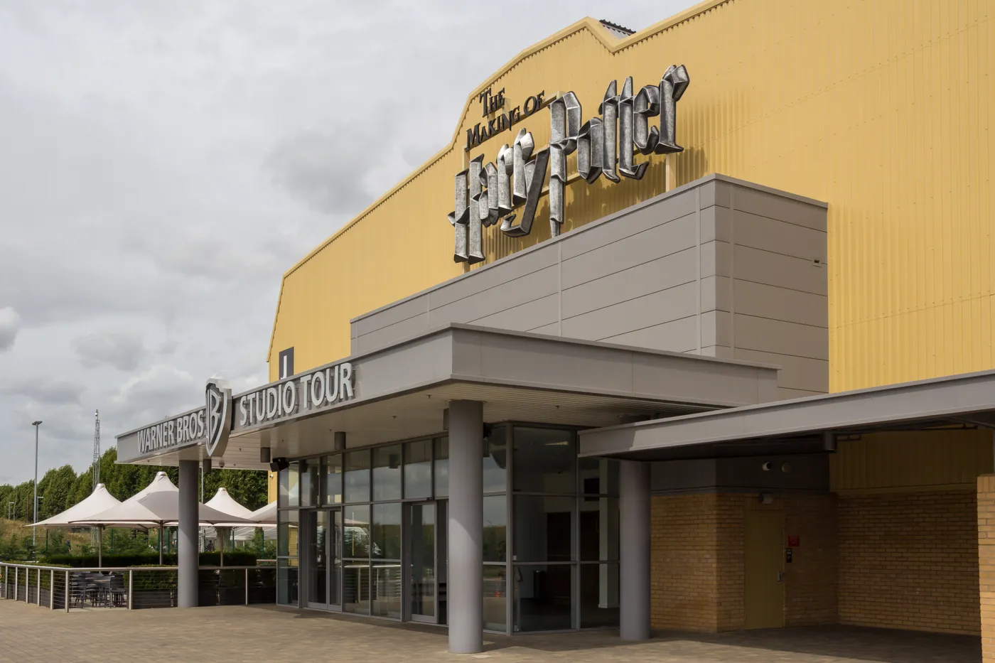 Exterior of the Warner Bros. Studio Tour building at Leavesden with large lettering above the entrance canopy