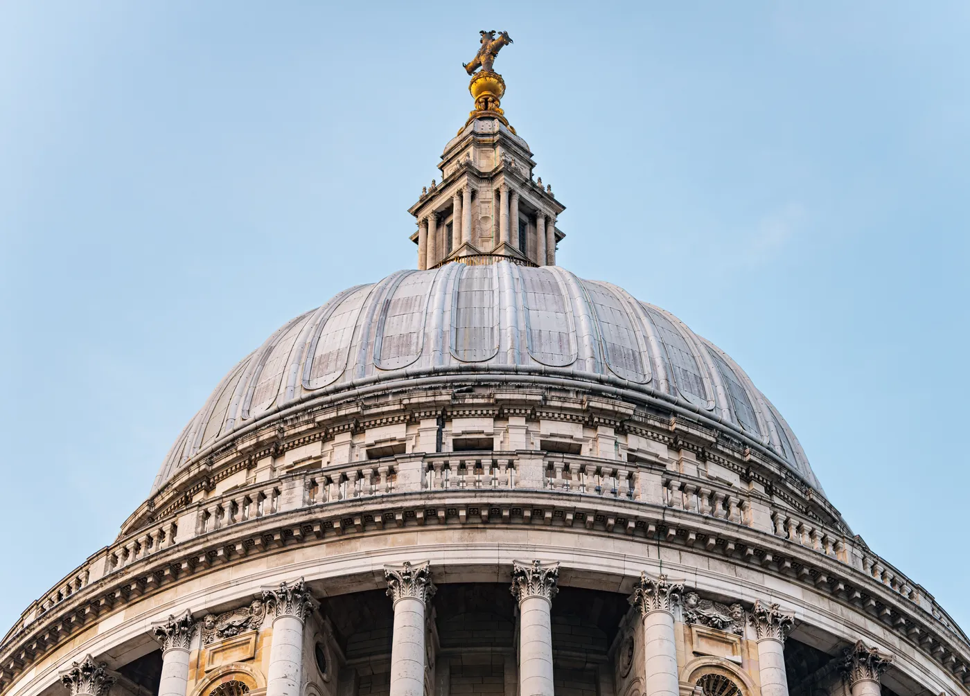The dome and lantern of St Paul's Cathedral against a pale blue sky