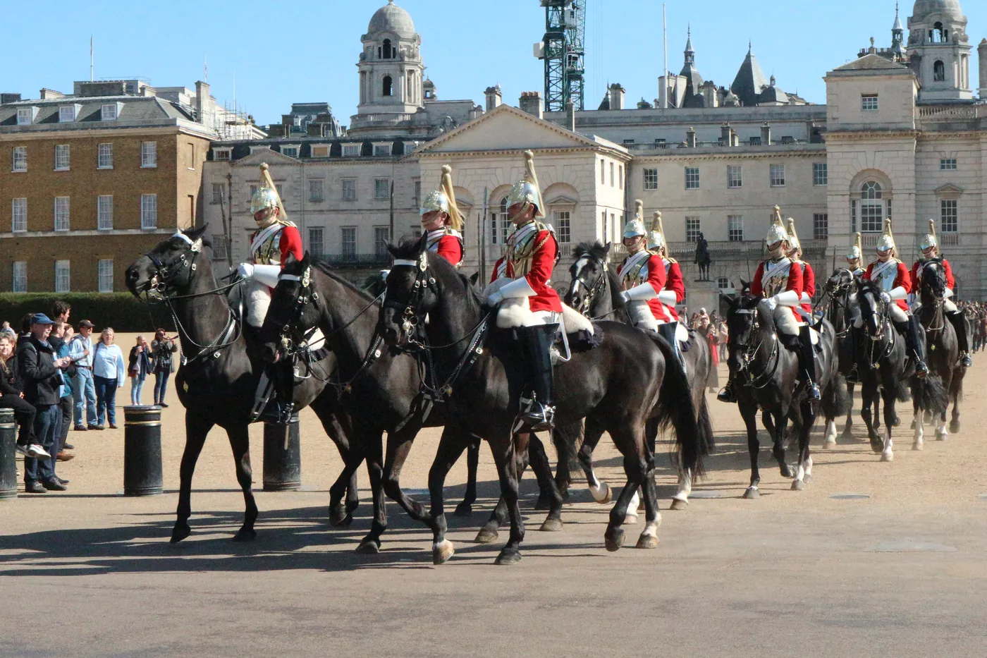 Mounted Household Cavalry troopers in red tunics crossing Horse Guards Parade